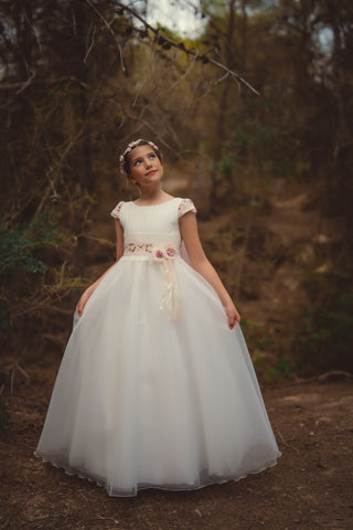 Vestido de comunión blanco con falda de vuelo y flores en la cintura.