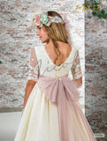 vestido de comunión con escote trasero en forma de V y gran lazada en tul rosa